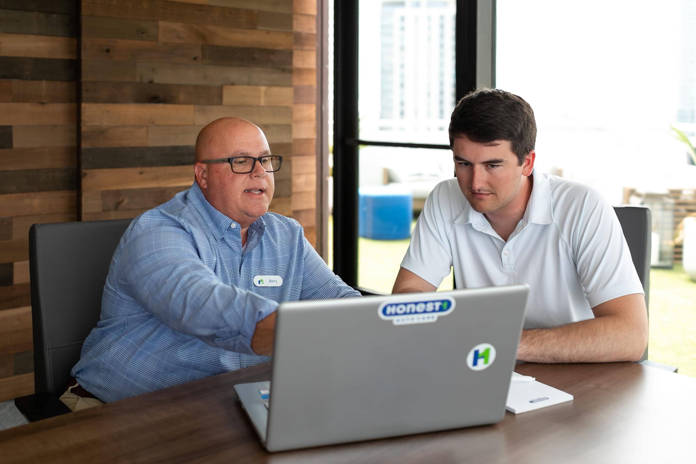 An Honest1 Auto Care representative in a meeting with a franchise owner.