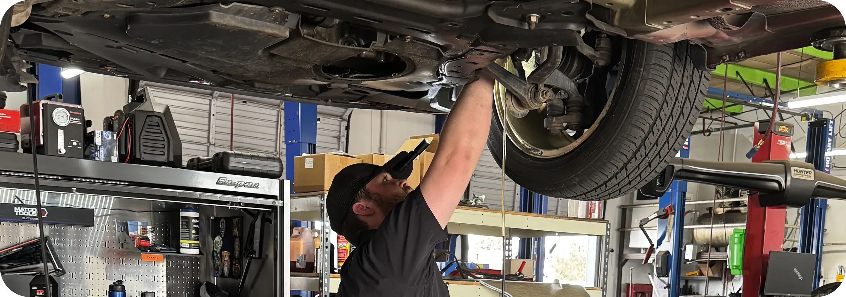 Honest1 Federal Heights Roadworthy Expert technician working under a lifted vehicle in the service bay